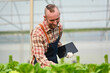 © Prathankarnpap - Male farmer holding digital tablet examining organic vegetable in greenhouse. Hydroponic plant harvest concept