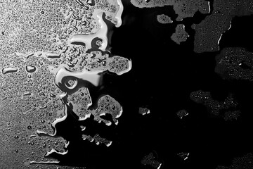 Wall Mural - Water puddle and droplets isolated on black background and texture, top view