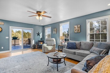 Poster - Beautiful suburban house interior with blue walls and sofas under a ceiling fan