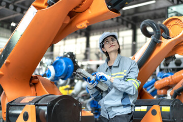 Sticker - Female industrial engineer maintenance mechanic orange robot frame then assembly to robotic automation machine. Industry 4.0 is robotization technology or smart digital automation in modern factory.