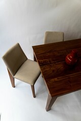 Sticker - Vertical shot of a wooden table,two chairs and a vase placed on the table against a white background