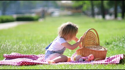 Sticker - Cheerful toddler girl having picnic near the Eiffel tower in Paris, France. Happy child playing with toys in park on a summer day. Kid enjoying healthy snacks outdoors