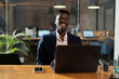 © JustLife - Portrait of successful businessman in office. Young smiling man using the laptop..
