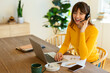 © Westend61 - Happy freelancer talking on headset sitting with laptop at home office