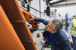 © Westend61 - Mature engineer examining robotic arm in industry