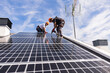 © Westend61 - Engineers installing solar panel under sky on sunny day