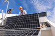 © Westend61 - Technicians installing solar panels on rooftop