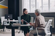 © gstockstudio - Senior woman having a meeting with financial advisor while sitting in the office together