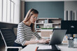 © gstockstudio - Confident young businesswoman using laptop while sitting at her working place in the office