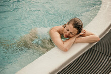 Woman With Eyes Closed Resting In Swimming Pool