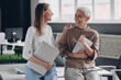 © gstockstudio - Two confident businesswomen communicating and smiling while standing in the office together