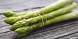 Fresh green asparagus on rustic gray wooden planks. Close-up with short depth of field. Background for healthy gastronomy with space for t