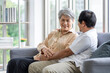 © SKW - Asian couple, elderly man and woman sitting on the sofa having fun chatting together at home. Concept: health insurance, life insurance, retirement happiness.