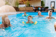 © Halfpoint - Multi generation family having fun and enjoying swimming in backyard pool during summer holiday.