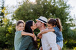 © Halfpoint - Portrait of young couple with their daughters in the nature, kissing. Side view.