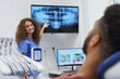 © Halfpoint - Young dentist showing x-ray image to patient.