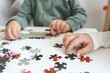 © shine.graphics - Brother and sister playing puzzles at home. Children connecting jigsaw puzzle pieces in a living room table. Kids assembling a jigsaw puzzle. Fun family leisure
