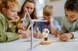 © Halfpoint - Young teacher with model of wind turbine learning pupils about wind energy.