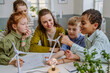 © Halfpoint - Young teacher with model of wind turbine learning pupils about wind energy.