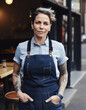 © Trinette Reed - Portrait of small business owner woman and chef standing in front of her cafe window wearing an apron. Generative AI.