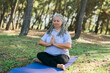 © satura_ - Mindful senior woman portrait with dreadlocks meditating on nature close up copy space - wellness and yoga practice