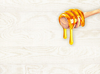 Canvas Print - honey dipper dripping  on a light wooden background