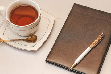 Wall Mural - White cup and saucer with golden spoon and notepad.