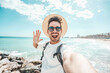 © Davide Angelini - Handsome young man taking selfie at beach summer vacation - Smiling guy having fun walking outside - Summertime holidays and technology concept