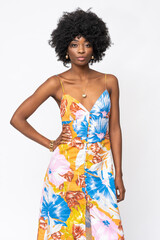 Wall Mural - Fashionable African woman with curly hairs and floral dress on isolated white background.