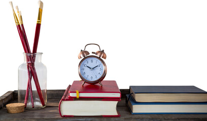 Poster - Books with alarm clock with books and paintbrushes on wooden table