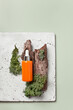 Beauty serum on pale green background withwood and moss, top view. Minimalistic scandi style, copy space