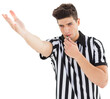 Referee showing gesture while blowing whistle