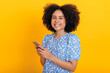 © Kateryna - Wireless technology. Positive african american or brazilian curly woman, using mobile phone, messaging in social media, reading news, browsing internet, smiles at camera, on isolated orange background