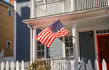 Wall Mural - The US flag on a pole is a symbol of patriotism and unity, representing the country's values, history, and people. Its design and colors have symbolic meaning