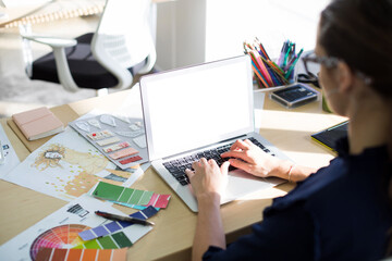 Canvas Print - Female executive using laptop while sitting at desk