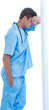 Upset surgeon leaning on pole