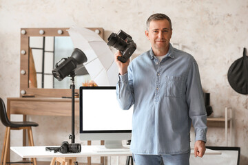 Mature photographer with professional camera in studio