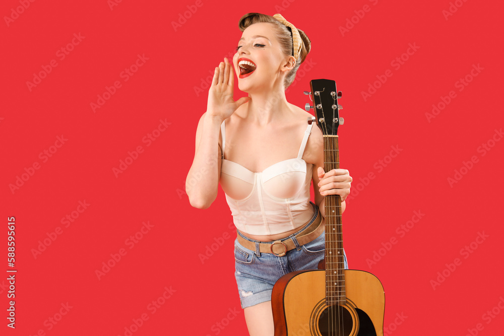 Young pin-up woman with guitar on red background