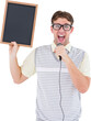 Geeky hipster holding blackboard and singing into microphone
