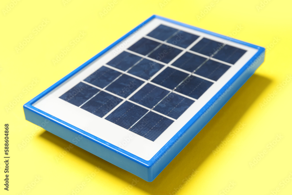 Portable solar panel on yellow background, closeup