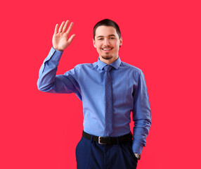 Wall Mural - Handsome businessman waving hand on red background