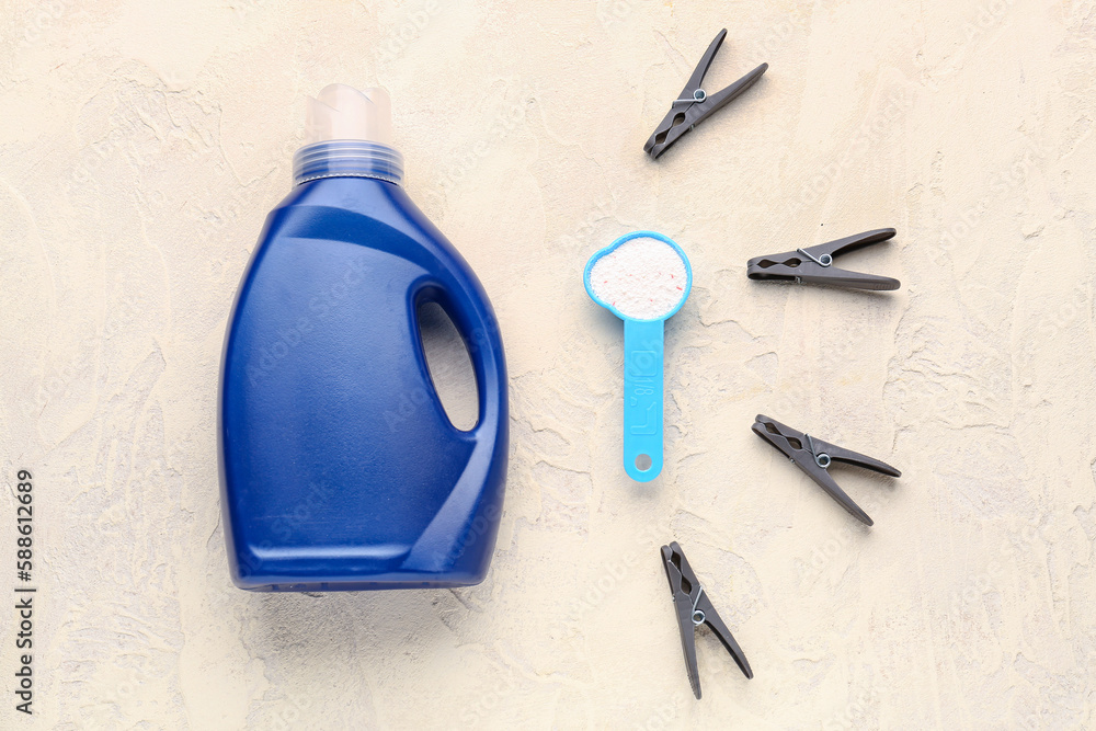 Laundry detergents and clothespins on grunge beige background