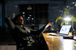 © Wavebreak Media - Biracial businessman sitting at desk, using laptop and working late at office