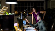 © Wavebreak Media - Diverse business people sitting at desk, using computer and talking, working late at office