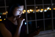 © Wavebreak Media - Asian businesswoman sitting at desk, using smartphone and working late at office
