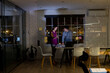 © Wavebreak Media - Diverse business people standing at desk, using laptop and discussing, working late at office