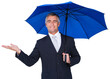 Smiling businessman holding blue umbrella with hand out