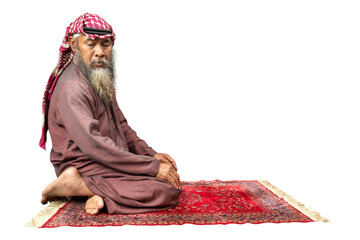 Muslim man with a beard wearing keffiyeh with agal in praying position (salat) on the prayer rug