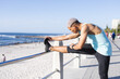 © Wavebreak Media - Biracial man wearing sportswear and stretching on promenade by the sea