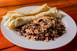 Traditional gallo pinto with Quesillo served on wooden table. Nicaraguan gallopinto with quesillo on the table. typical nicaraguan foods